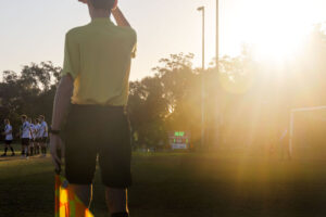 Referee trying to read electronic scoreboard while staring into the sun.