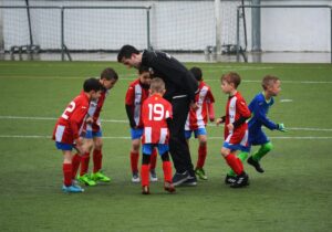 coach and kids practising soccer