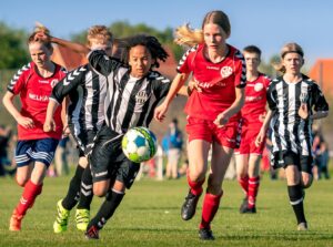 girls red and black soccer teams playing a game